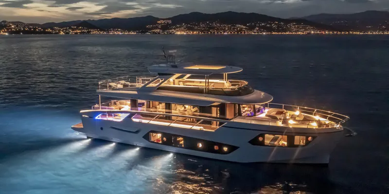 Slide: The Image of Luxurious 2025 Absolute NAVETTA 75 yacht illuminated at night on serene waters. - 4