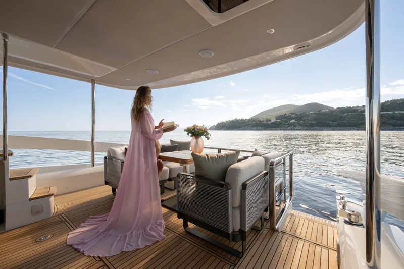 Slide: The Image of Een vrouw in een lange jurk staat op het dek van een jacht met uitzicht op zee. - 7