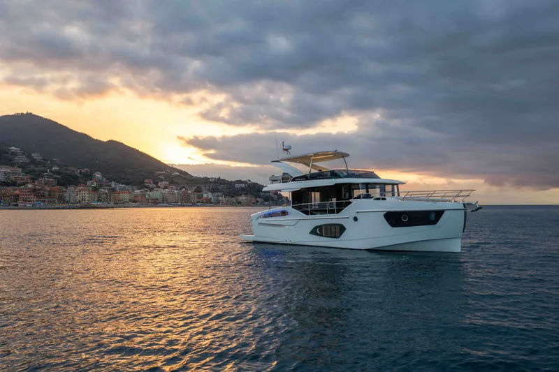Slide: The Image of Luxury Absolute 50 Navetta yacht cruising at sunset, 2027 model, near scenic coastline. - 5