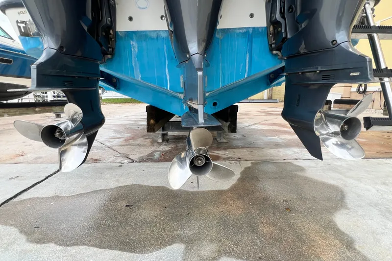 Slide: The Image of Triple outboard motors on a 2007 SeaVee 340B Open boat, docked on concrete. - 8