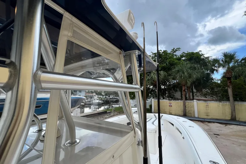 Slide: The Image of 2007 SeaVee 340B Open boat with T-top and rod holders, docked near palm trees. - 58