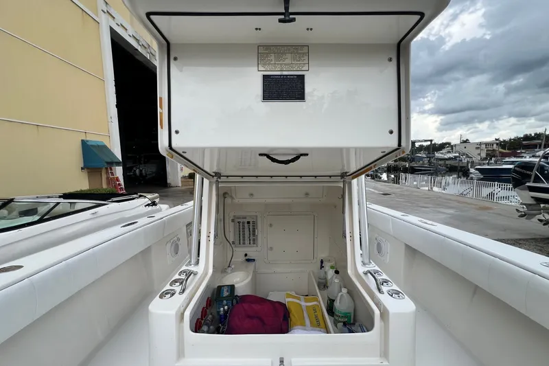 Slide: The Image of 2007 SeaVee 340B Open boat storage compartment with various items, dockside view. - 81