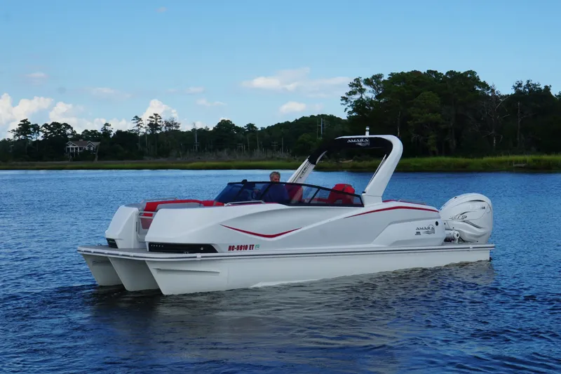 Slide: The Image of 2021 Amara pontoon boat cruising on a serene lake with lush greenery. - 5