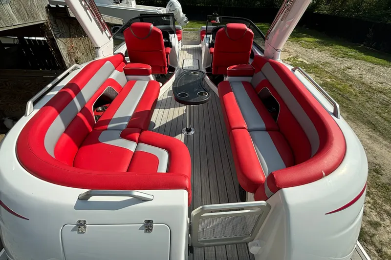 Slide: The Image of Red and gray seating on 2021 Amara pontoon boat, featuring sleek design and central table. - 14