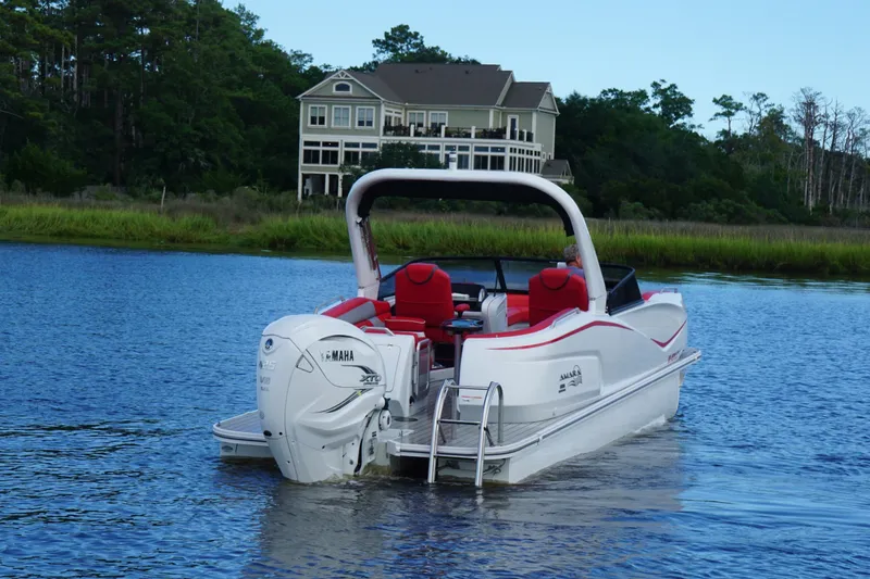 Slide: The Image of 2021 Amara pontoon boat on a serene lake with a house in the background. - 3
