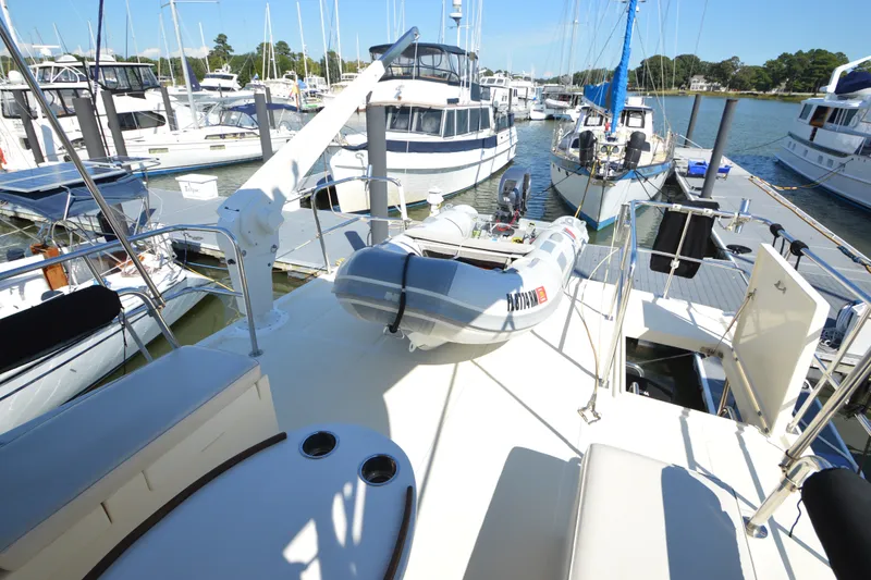 Slide: The Image of 2012 North Pacific Yachts 43 at marina with inflatable dinghy on deck. - 48