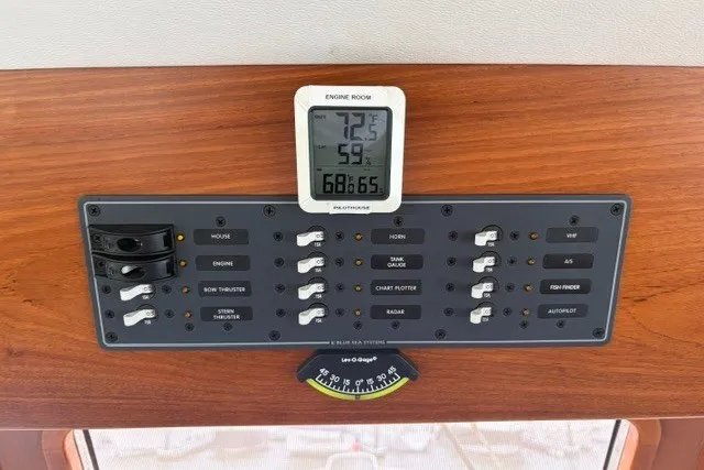 Slide: The Image of Control panel of a 2012 North Pacific Yachts 43, featuring switches and a digital thermometer. - 18