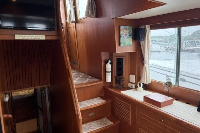 Slide: The Image of Interior of 2012 North Pacific Yachts 43, featuring wooden stairs and large windows. - 24