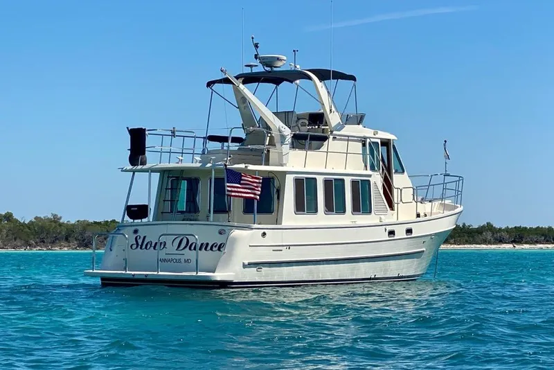 Slide: The Image of 2012 North Pacific Yachts 43 boat named "Slow Dance" on turquoise water. - 1