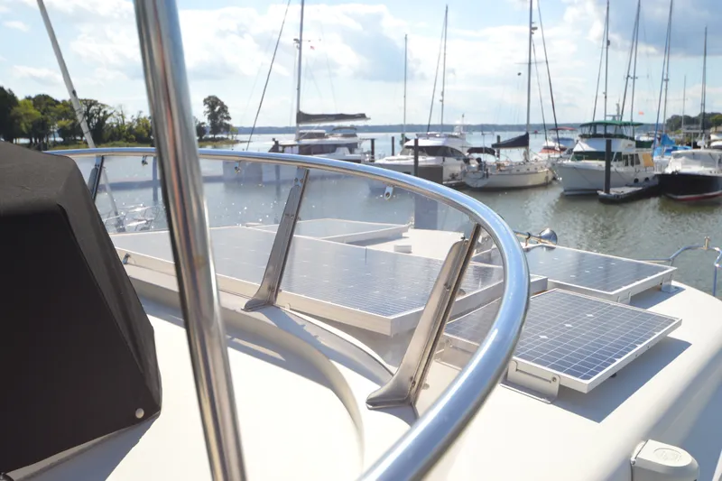 Slide: The Image of North Pacific Yachts 43 (2012) with solar panels, docked at a marina under a sunny sky. - 33