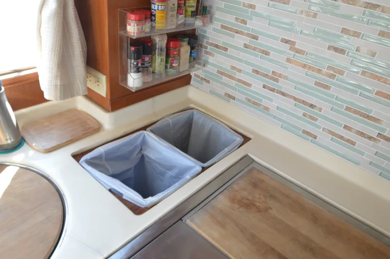 Slide: The Image of Galley kitchen in 2012 North Pacific Yachts 43 with spice rack and dual trash bins. - 57