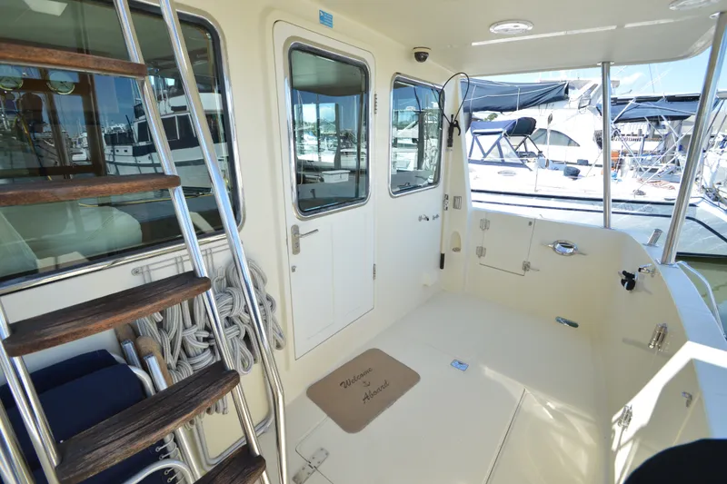 Slide: The Image of 2012 North Pacific Yachts 43 cockpit with ladder, ropes, and marina view. - 49