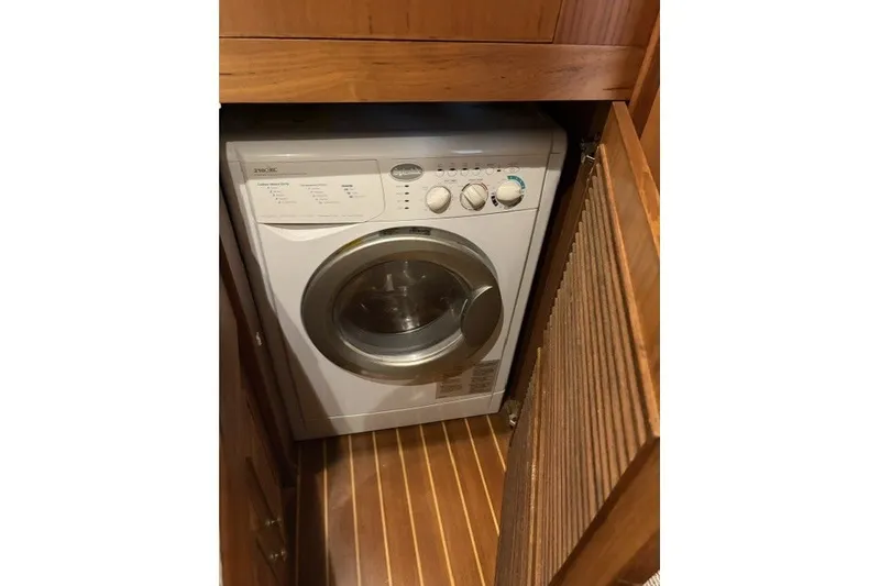Slide: The Image of Washing machine inside 2012 North Pacific Yachts 43, wooden cabinet, compact design. - 79