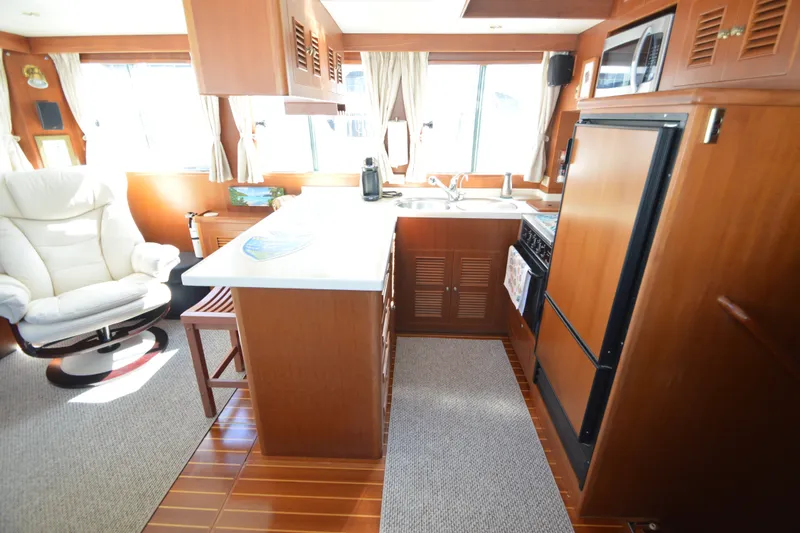 Slide: The Image of Luxurious interior of 2012 North Pacific Yachts 43, featuring a modern kitchen and comfortable seating. - 52