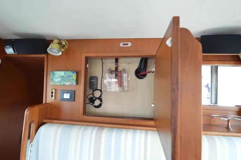 Slide: The Image of Interior of 2012 North Pacific Yachts 43, featuring electrical panel and wooden cabinetry. - 73