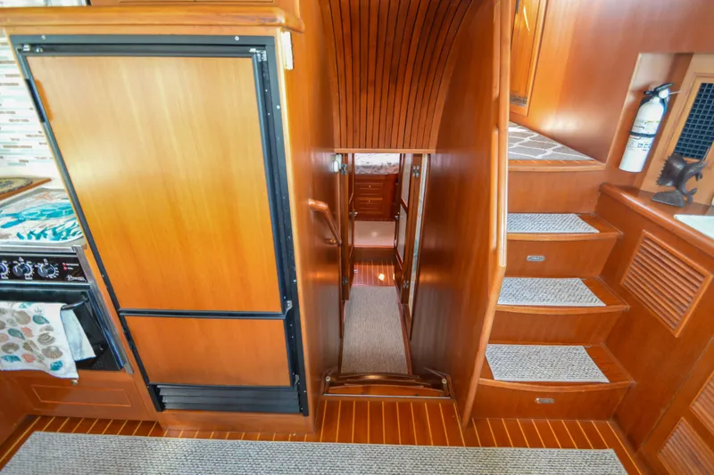 Slide: The Image of Interior of 2012 North Pacific Yachts 43, featuring wooden cabinetry and staircase. - 83