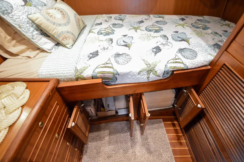 Slide: The Image of Cozy cabin interior of 2012 North Pacific Yachts 43 with nautical-themed bedding and wooden storage. - 78