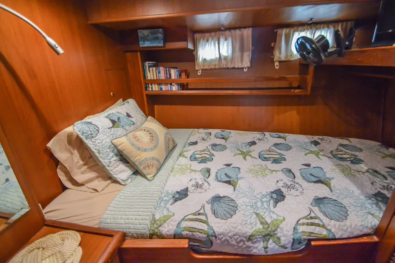 Slide: The Image of Cozy cabin interior of 2012 North Pacific Yachts 43 with nautical-themed bedding and wooden shelves. - 76