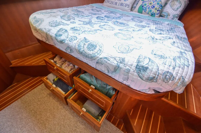 Slide: The Image of Cozy bedroom with seashell-themed bedding and under-bed storage on a 2012 North Pacific Yachts 43. - 75