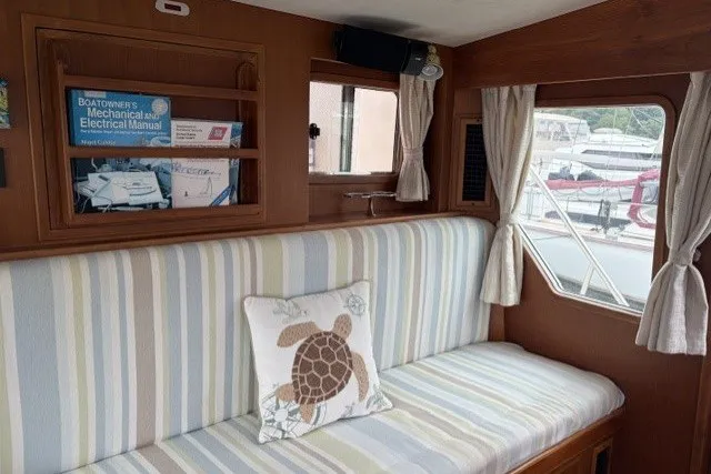 Slide: The Image of Interior of 2012 North Pacific Yachts 43 with striped seating and turtle-themed pillow. - 12