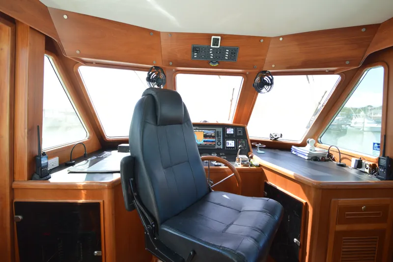 Slide: The Image of Pilothouse interior of 2012 North Pacific Yachts 43, featuring navigation equipment and captain's chair. - 62