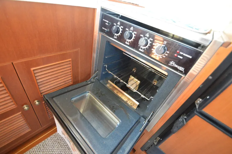 Slide: The Image of Interior of 2012 North Pacific Yachts 43, featuring a built-in oven and wooden cabinetry. - 54