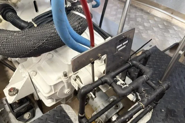 Slide: The Image of Engine compartment of a 2012 North Pacific Yachts 43, featuring hoses and mechanical components. - 100