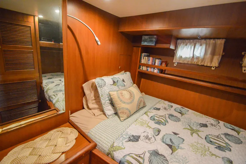 Slide: The Image of Cozy cabin interior of 2012 North Pacific Yachts 43, featuring a comfortable bed and wooden decor. - 77