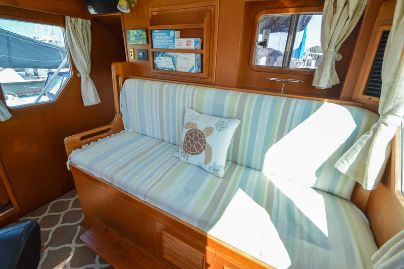 Slide: The Image of Interior of 2012 North Pacific Yachts 43 with striped seating and turtle-themed pillow. - 61