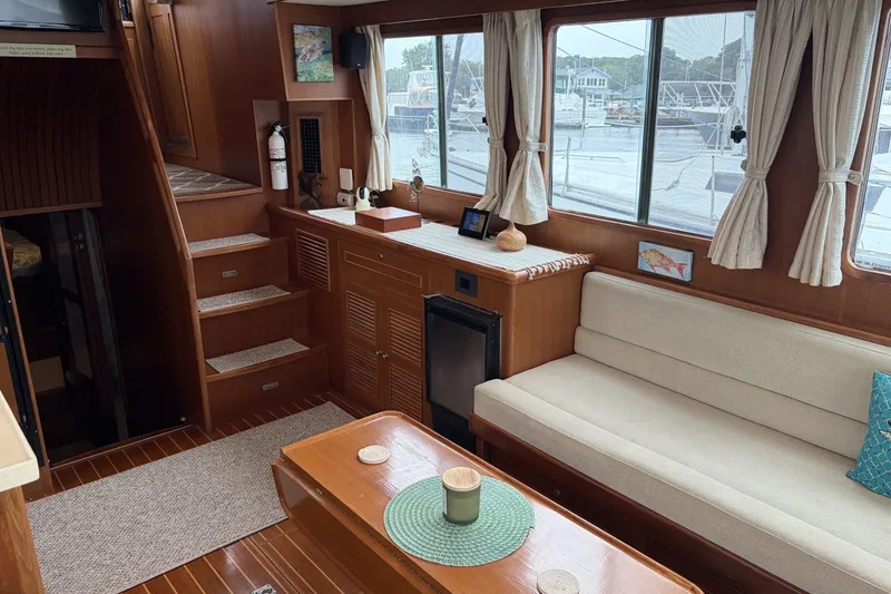 Slide: The Image of Interior of 2012 North Pacific Yachts 43, featuring cozy seating and wooden finishes. - 8