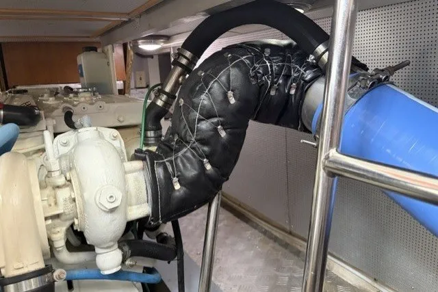 Slide: The Image of Engine room of 2012 North Pacific Yachts 43, featuring insulated exhaust system and piping. - 103