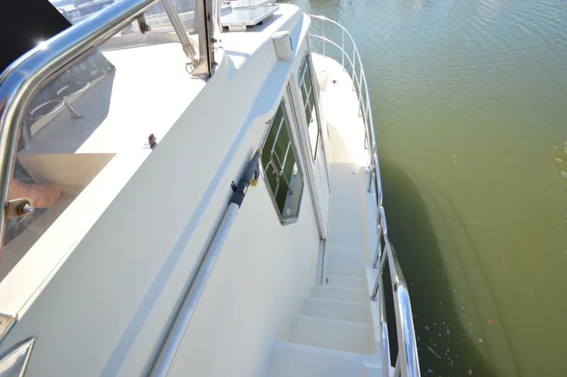 Slide: The Image of Side view of 2012 North Pacific Yachts 43, showcasing deck and railing over water. - 34