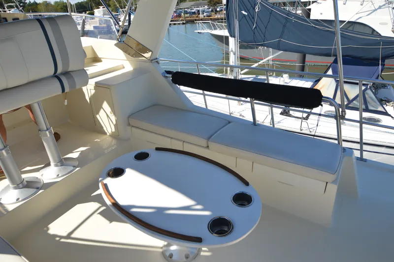 Slide: The Image of Flybridge seating area on a 2012 North Pacific Yachts 43, featuring cushioned seats and a round table. - 44
