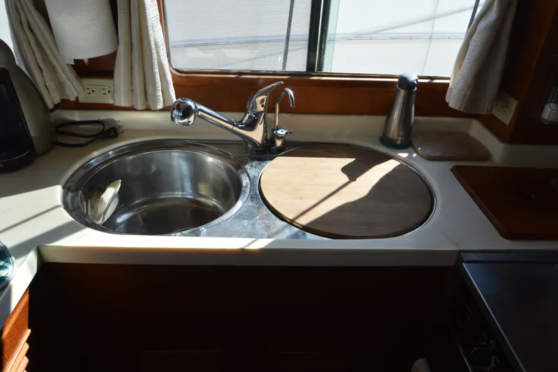 Slide: The Image of Kitchen sink area in a 2012 North Pacific Yachts 43, featuring a round cutting board. - 56