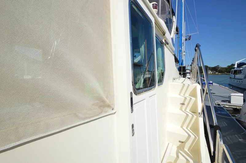 Slide: The Image of 2012 North Pacific Yachts 43 side view with steps and railing, docked under clear blue sky. - 37