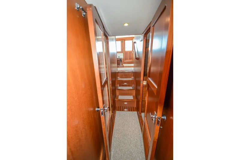 Slide: The Image of Interior hallway of 2012 North Pacific Yachts 43, featuring wooden doors and carpeted flooring. - 82