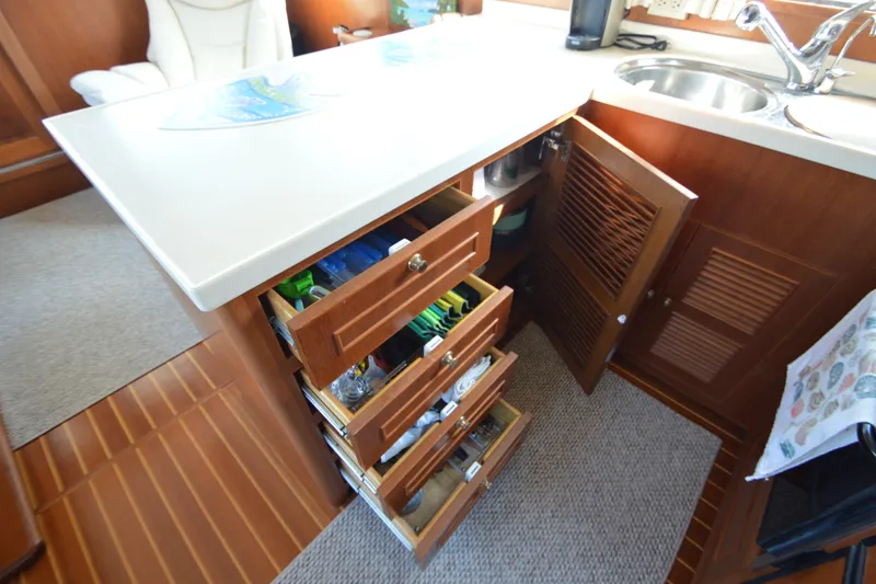 Slide: The Image of Luxurious 2012 North Pacific Yachts 43 kitchen with open drawers and cabinets, showcasing ample storage. - 63