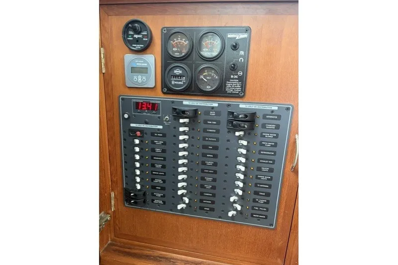 Slide: The Image of Electrical control panel of a 2012 North Pacific Yachts 43, featuring gauges and switches. - 17