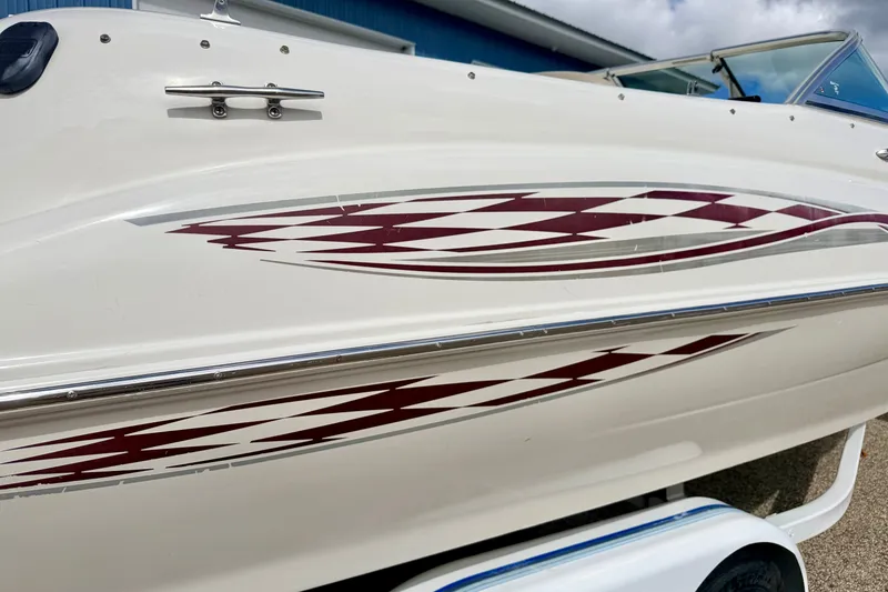 Slide: The Image of 2000 Sea Ray 210 Sundeck boat with red and white graphics on the side. - 13