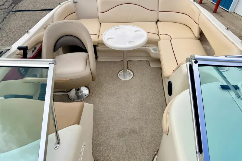 Slide: The Image of 2000 Sea Ray 210 Sundeck interior with beige seating and round table. - 55