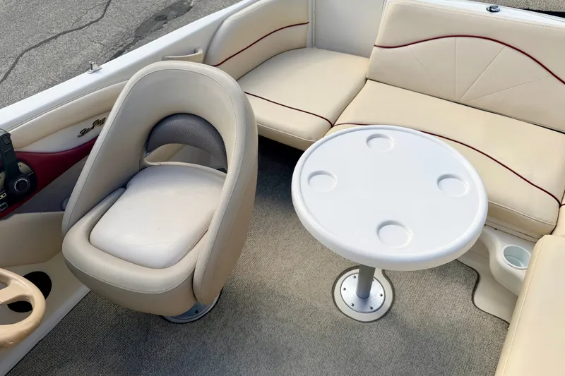 Slide: The Image of Interior of 2000 Sea Ray 210 Sundeck with beige seating and round table. - 67