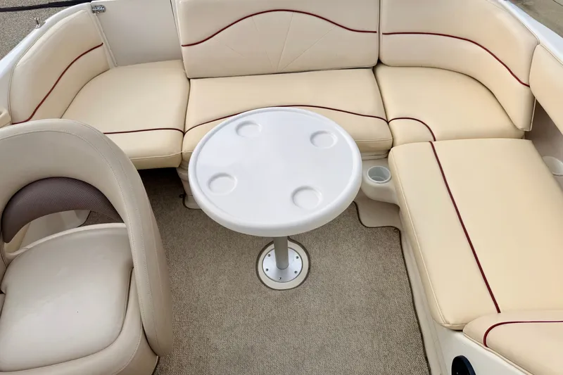 Slide: The Image of Interior of 2000 Sea Ray 210 Sundeck with beige seating and round table. - 47