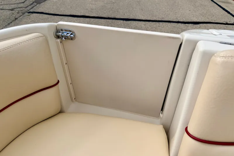 Slide: The Image of Interior view of a 2000 Sea Ray 210 Sundeck boat, featuring beige seating and a white panel. - 22