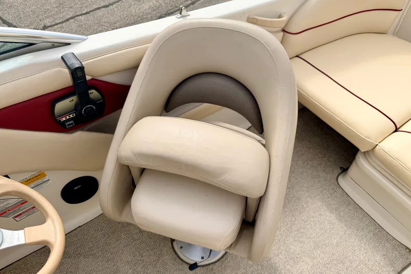 Slide: The Image of 2000 Sea Ray 210 Sundeck interior with beige seating and control panel. - 44