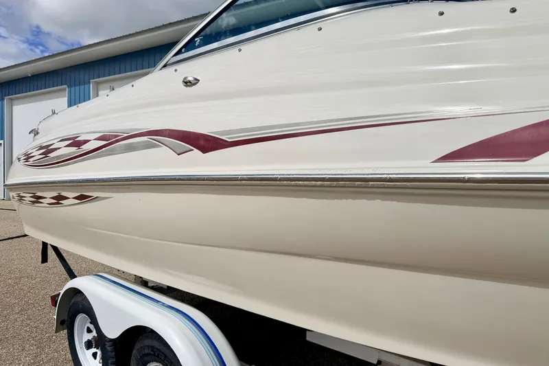 Slide: The Image of 2000 Sea Ray 210 Sundeck boat on trailer, featuring sleek design and maroon graphics. - 12