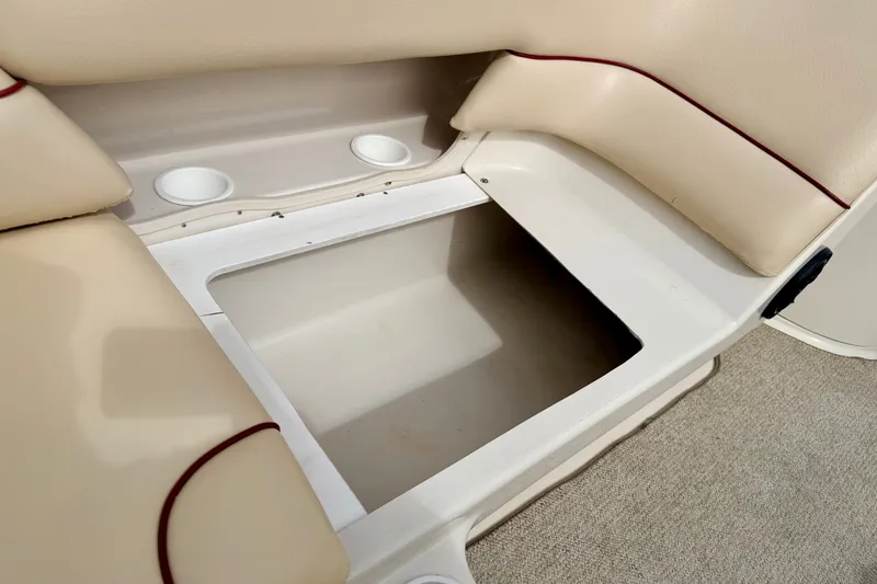 Slide: The Image of Storage compartment on a 2000 Sea Ray 210 Sundeck boat with beige seating. - 31