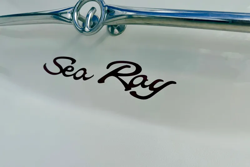 Slide: The Image of Sea Ray 210 Sundeck 2000 logo on boat surface with chrome detail. - 15