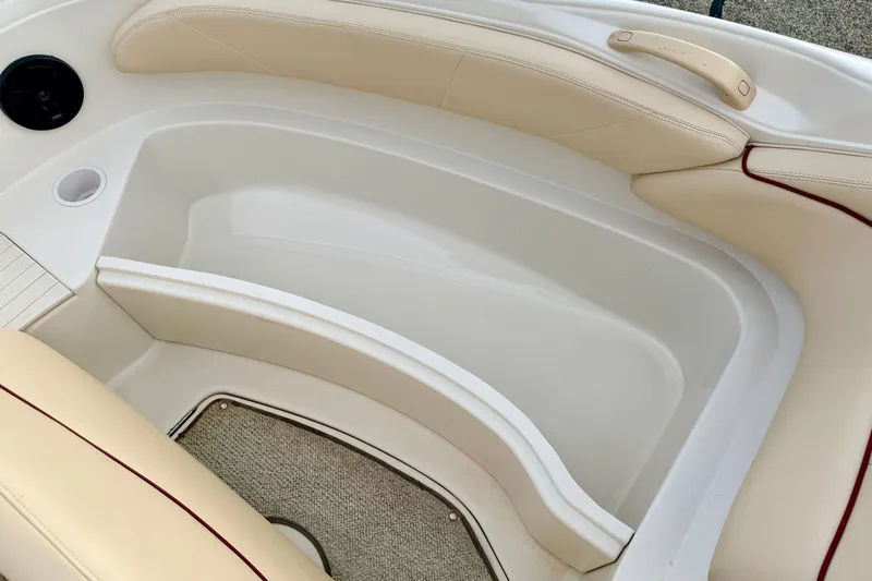 Slide: The Image of Interior seating of a 2000 Sea Ray 210 Sundeck boat with beige upholstery. - 52