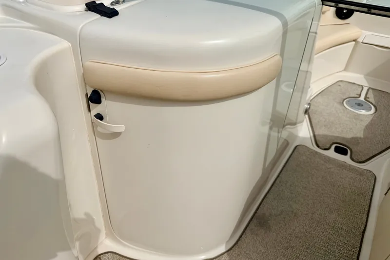 Slide: The Image of 2000 Sea Ray 210 Sundeck interior detail with beige accents and carpeted flooring. - 45