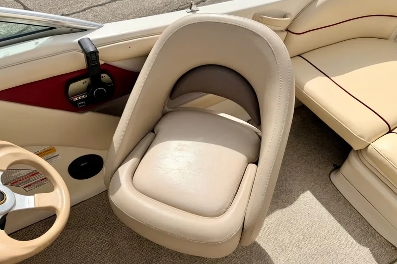 Slide: The Image of Interior of 2000 Sea Ray 210 Sundeck boat with beige seating and steering wheel. - 43